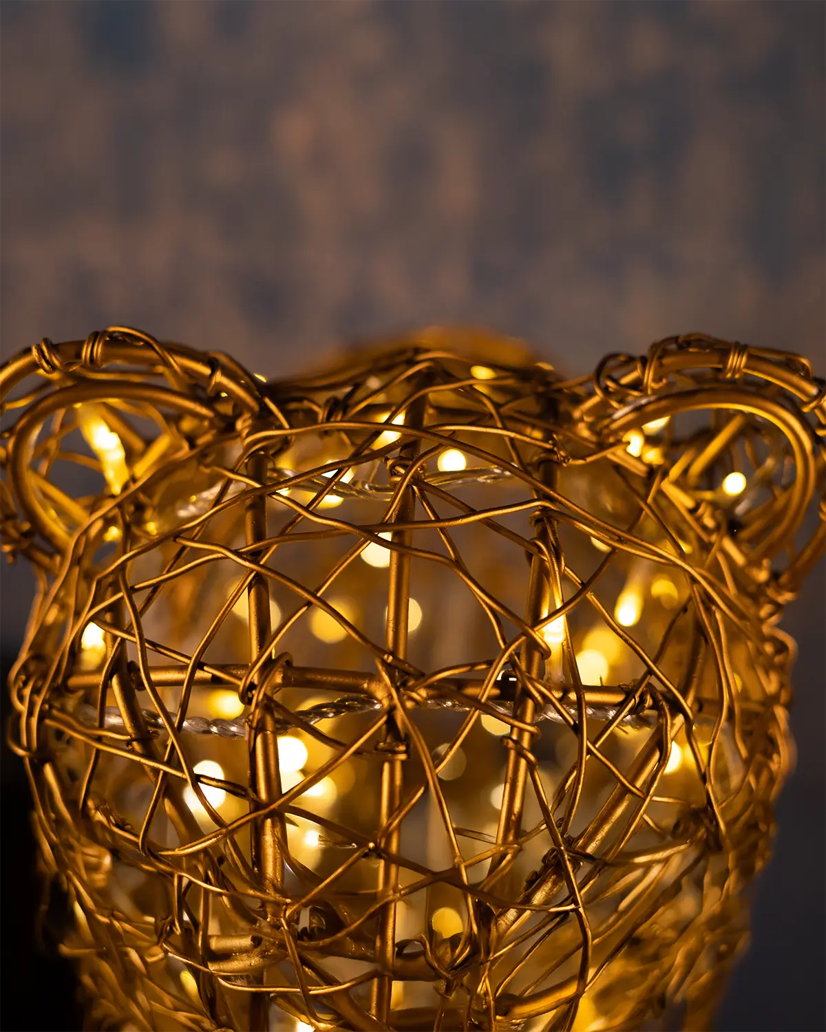 Detailaufnahme einer Lichtskulptur in Bärenform – goldene Drahtstruktur mit integrierten LED-Lichtern, stimmungsvoll inszeniert im Nahbereich.