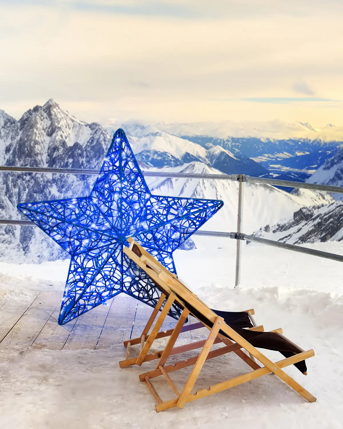 lauer Weihnachtsstern aus Draht als Lichtobjekt auf einer verschneiten Bergterrasse – inszeniert neben zwei Liegestühlen mit Alpenblick.