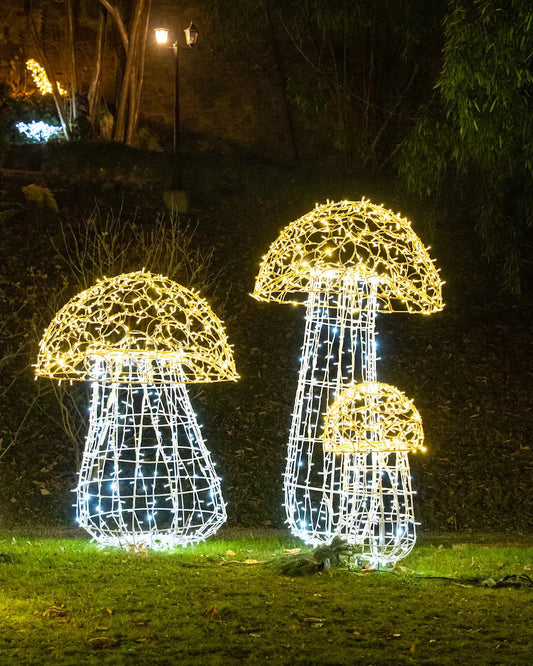 Drei leuchtende Pilzobjekte aus Draht und LED – winterliche Installation für Garten, Park oder Hotelfläche.